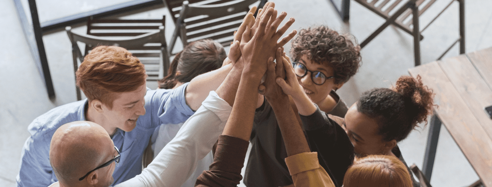 Stock photo: group of people in huddle with hands touching